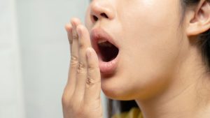 A Woman Checking Her Breath With a Hand Test